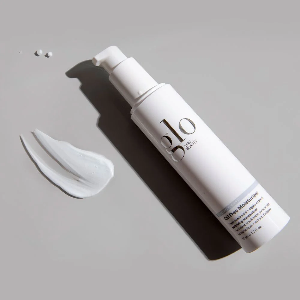 Glo Skin Beauty Oil Free Moisturizer bottle with a pump and a swatch of cream on a gray background