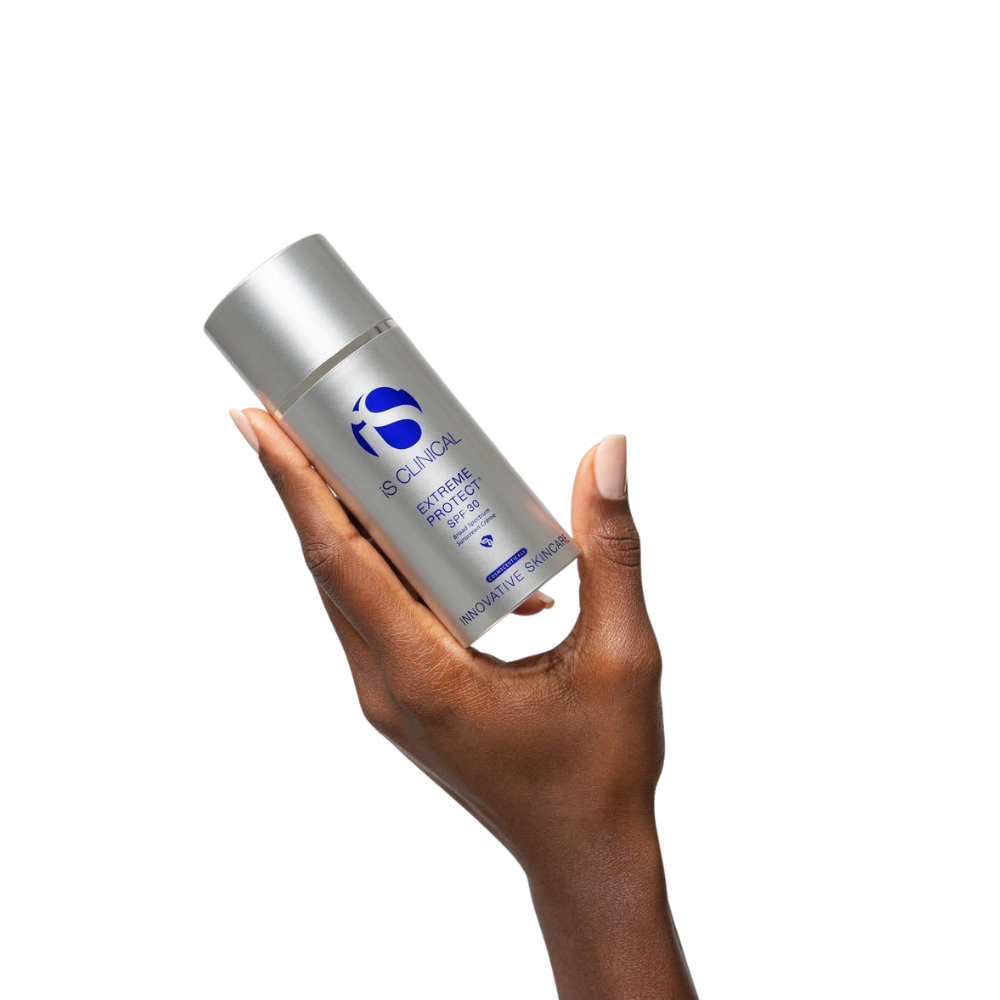 Hand holding a silver bottle of iS Clinical Extreme Protect SPF 30