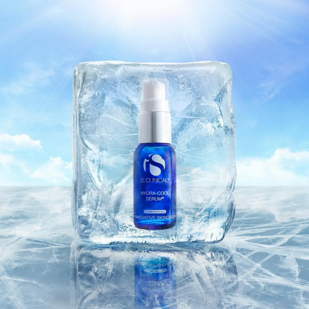 Bottle of iS Clinical Hydra-Cool Serum in a block of ice with a blue sky background