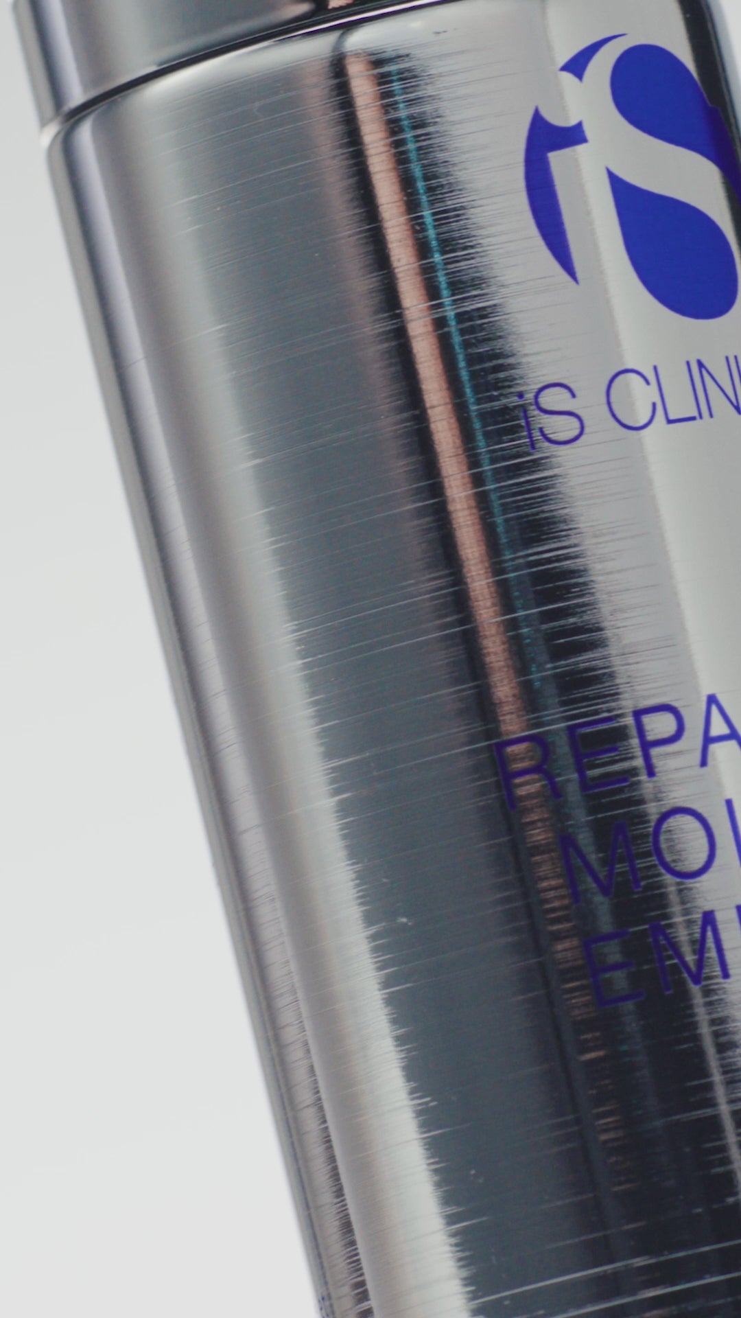 Video of silver tube of iS Clinical Reparative Moisture Emulsion being pumped onto a woman's hands and applied on face