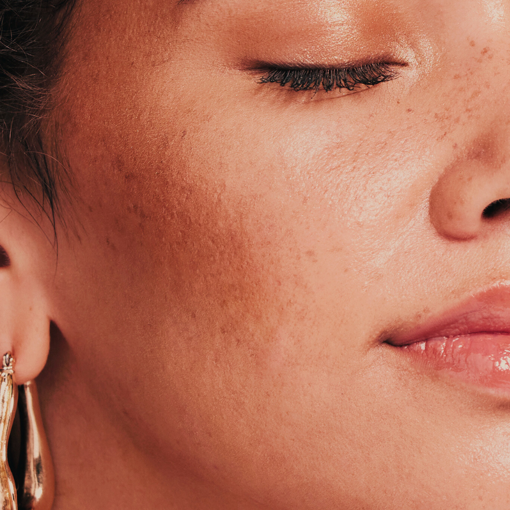 Close-up of a person wearing gold earrings with a soft focus on the face.