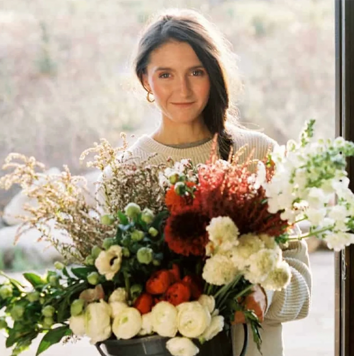 image of Tieghan Gerard holding flowers in a bucket