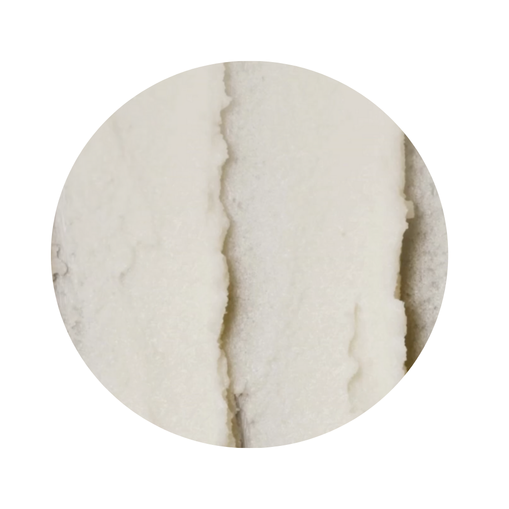 Close-up of textured surface with white lip scrub in the iS Clinical Lip Duo 