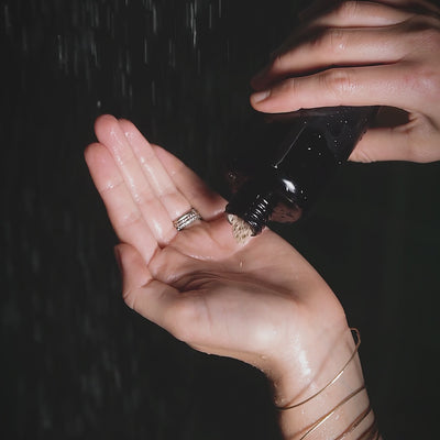 May Lindstrom The Clean Dirt being mixed with water and applied to face and neck of a woman in the shower 