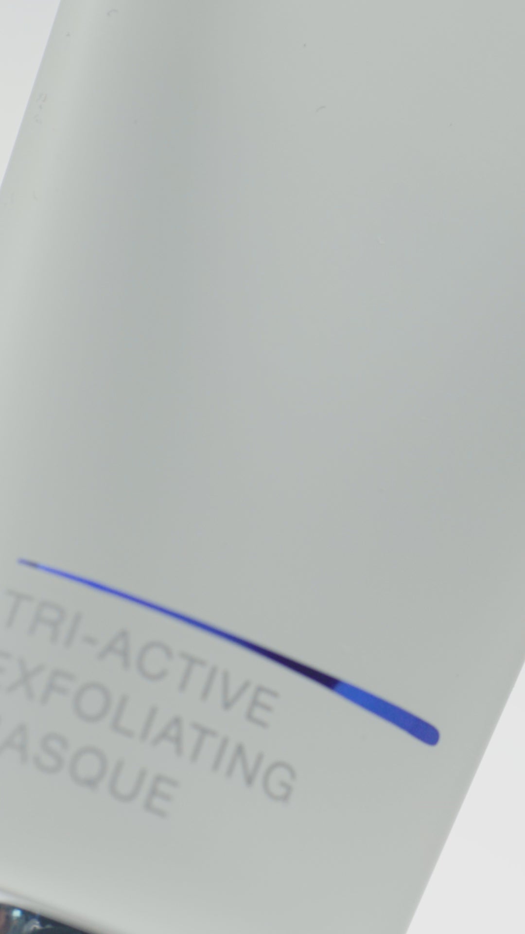 Video of white tube of iS Clinical Tri-Active Exfoliating Masque being squeezed onto fingertips and applied to a woman's face