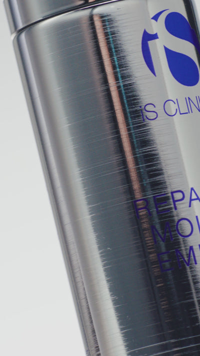 Video of silver tube of iS Clinical Reparative Moisture Emulsion being pumped onto a woman's hands and applied on face