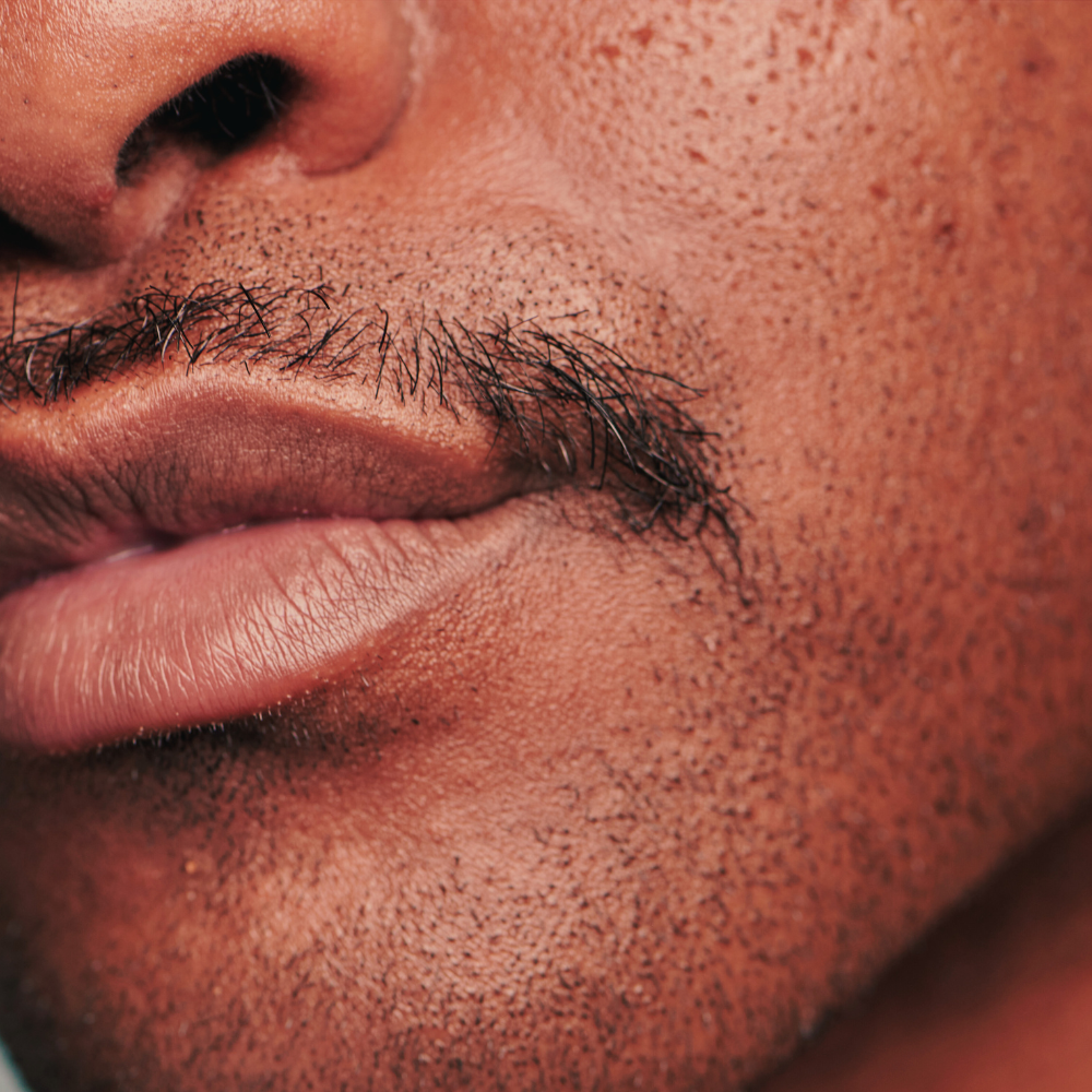 Close-up of a person's mouth and chin with a blurred background